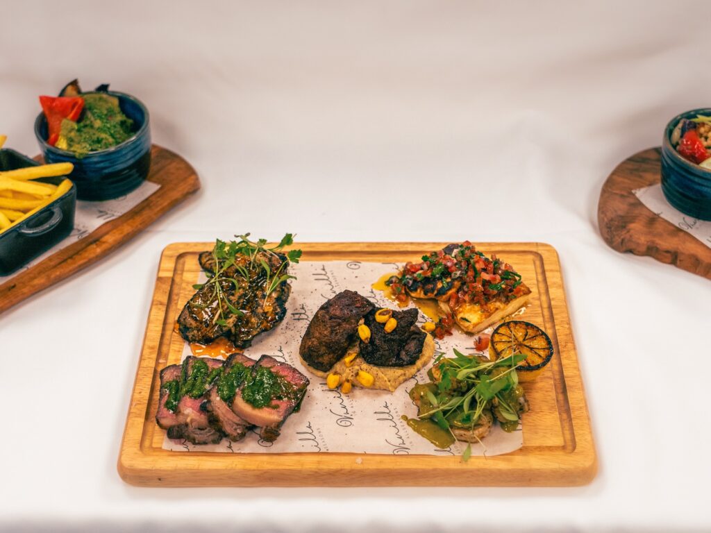 Succulent gourmet meats and tapas served on a wooden platter at Vanilla In Allseasons.